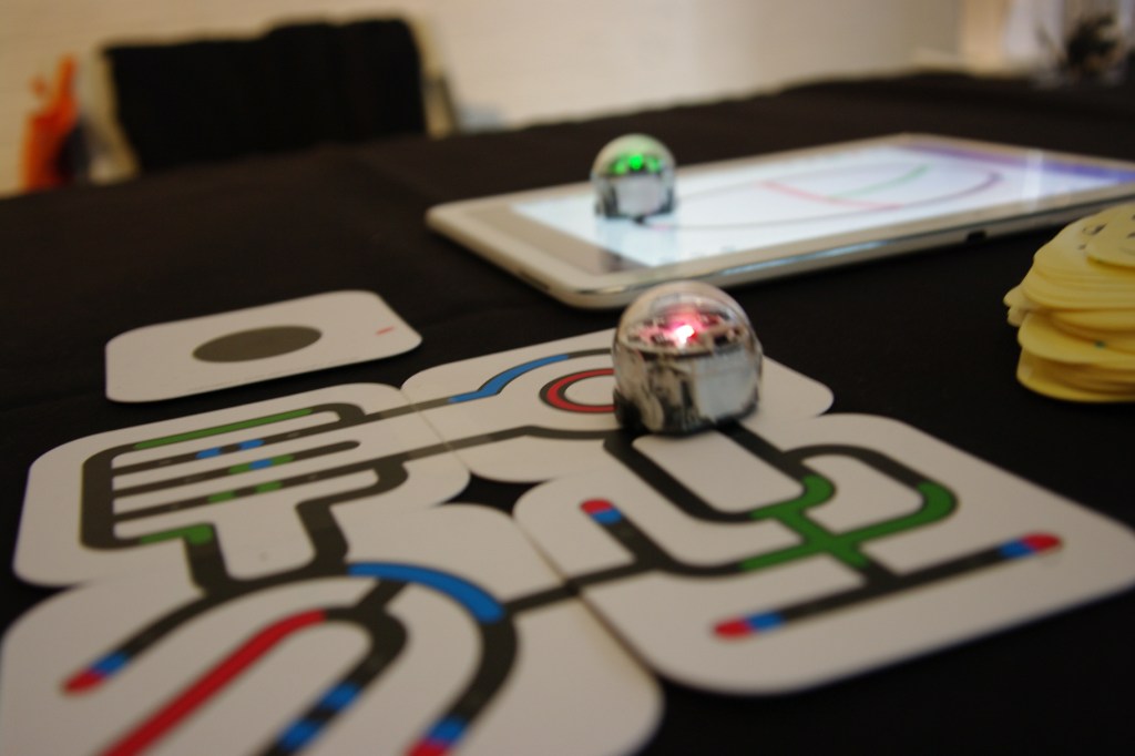 Ozobot following lines, colors and patterns on both paper and a tablet to help teach kids about robotics and programming.